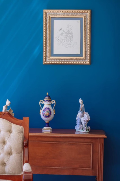 Recibidor con mueble de madera, porcelanas y un cuadro
