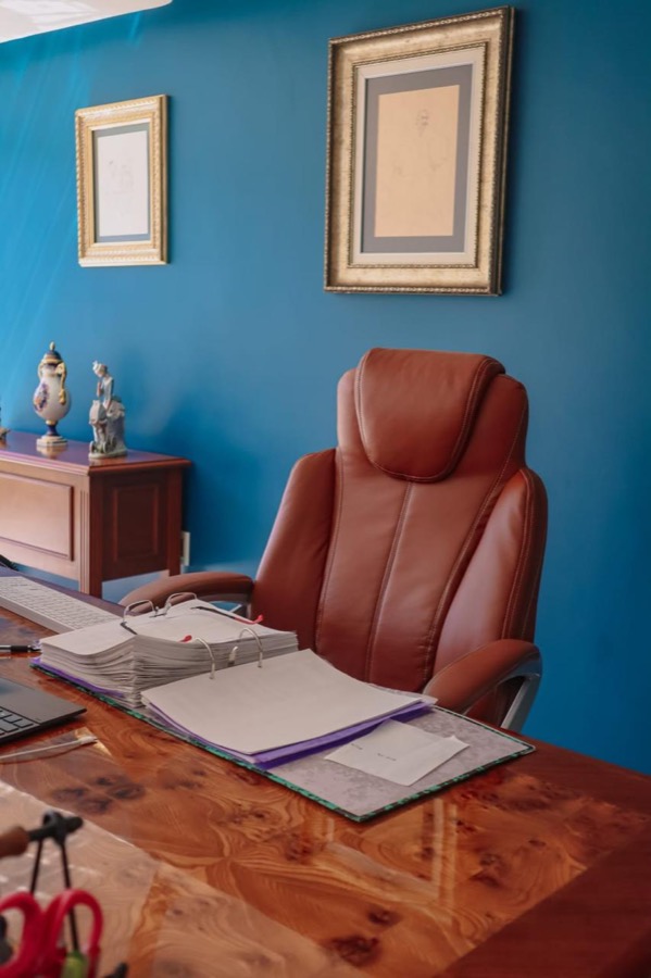 Escritorio de dirección con expedientes y pared azul